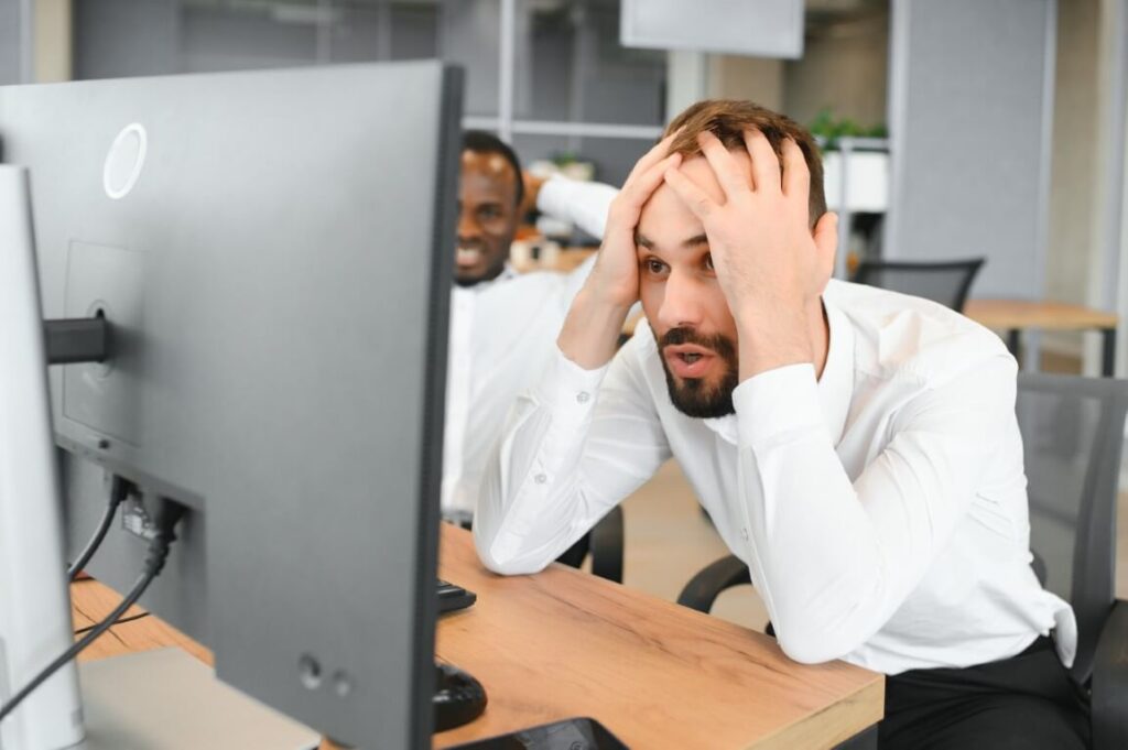 Man looking stressed in front of a computer