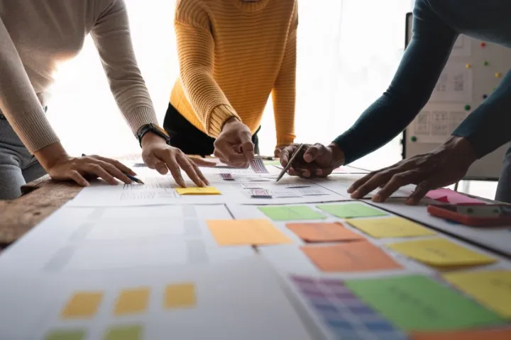 People reviewing notes on a feedback board